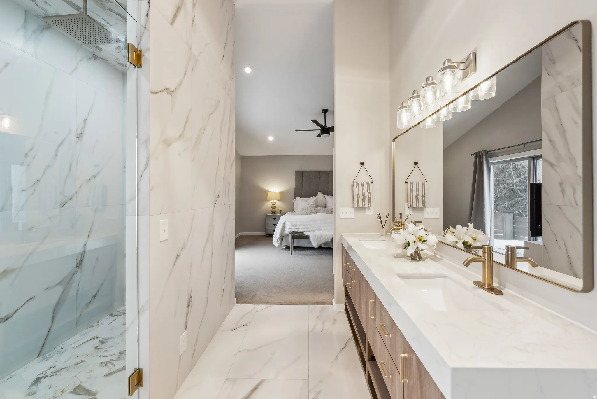 Ensuite bathroom with a ceiling fan, double vanity, light marble finish flooring, recessed lighting, and a marble finish shower