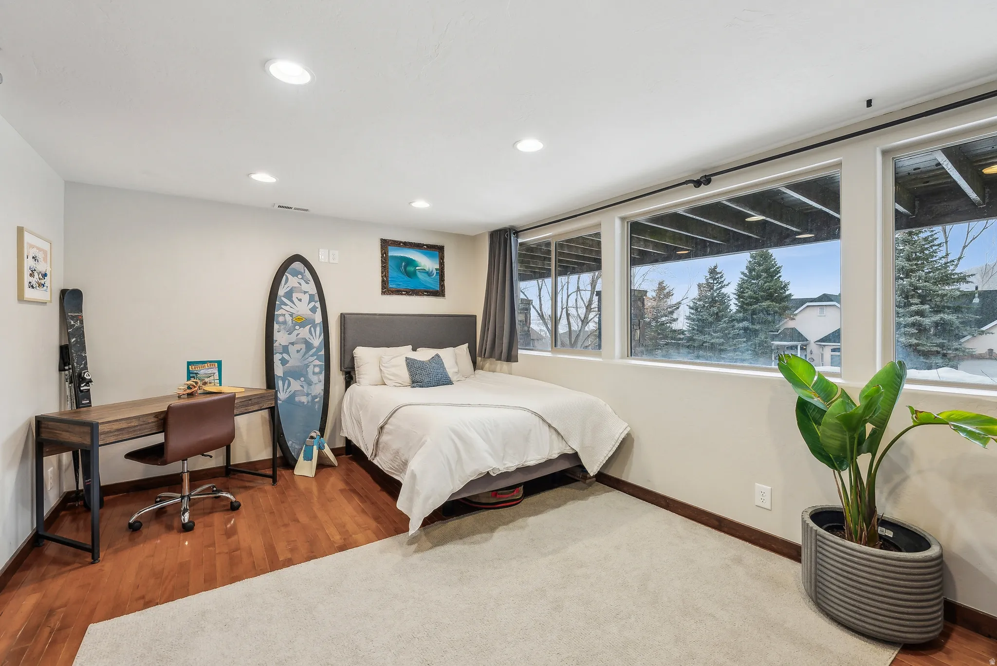 Recessed lighting, large windows, wood-finish flooring, light-toned walls, and soft carpeting