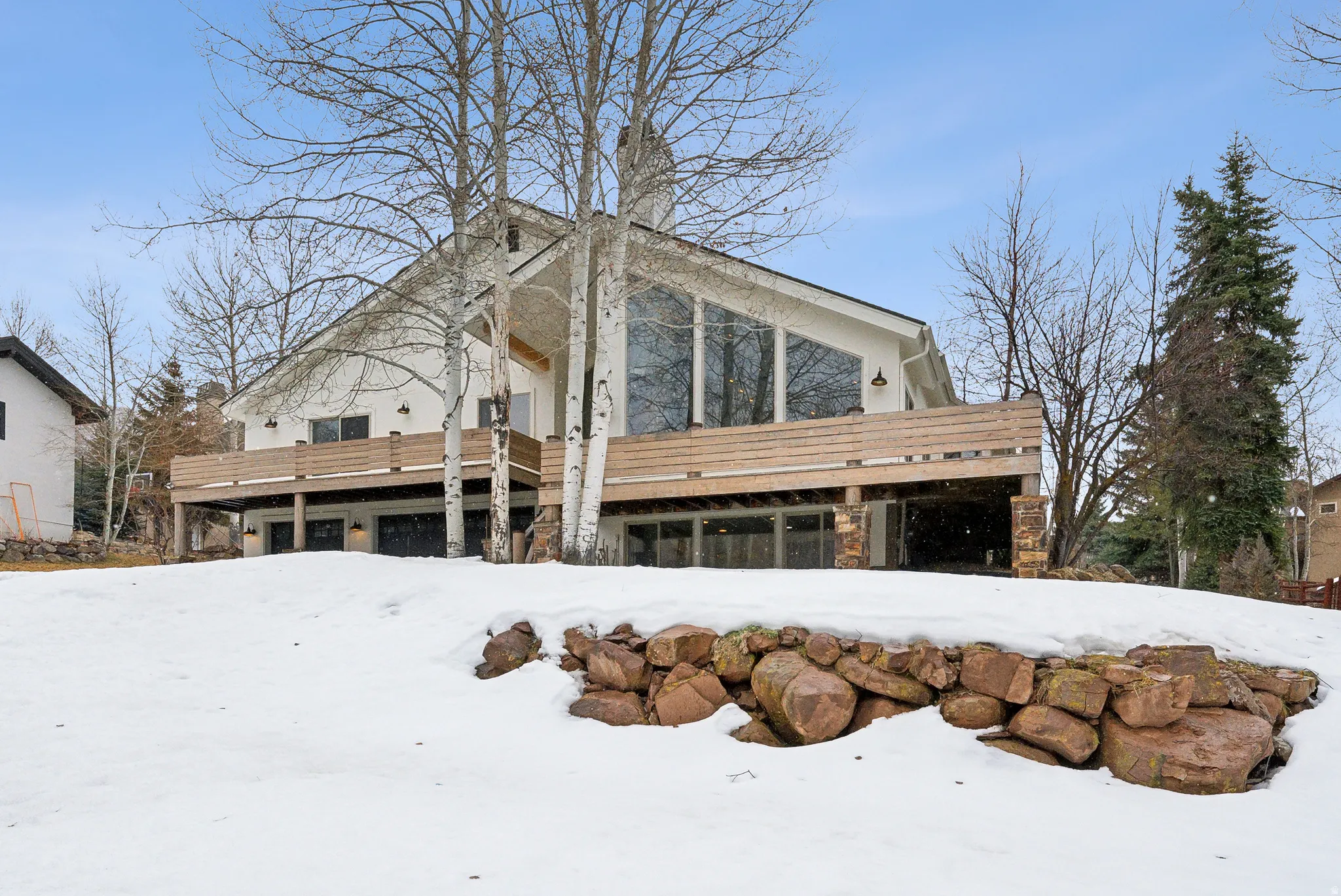 View of snowy exterior featuring stone siding
