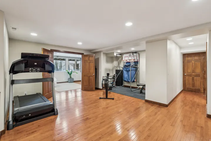 Wood-finish flooring, recessed lighting, and warm wood doors