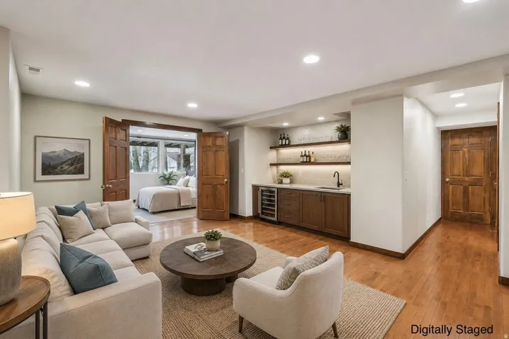 Wood-finish flooring, recessed lighting, and a built-in wet bar with a wine refrigerator