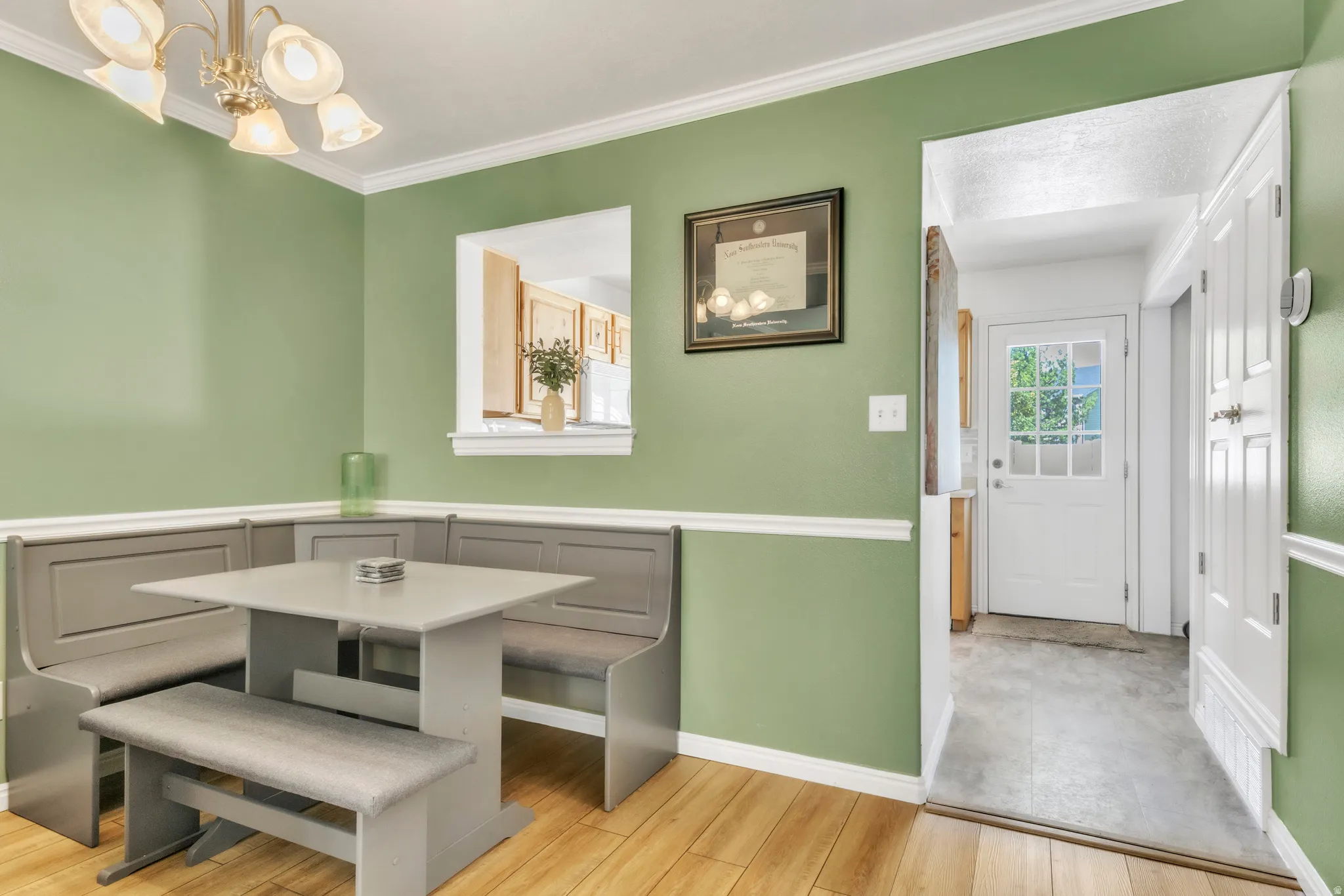 Dining room featuring light wood-type flooring, a chandelier, and ornamental molding
