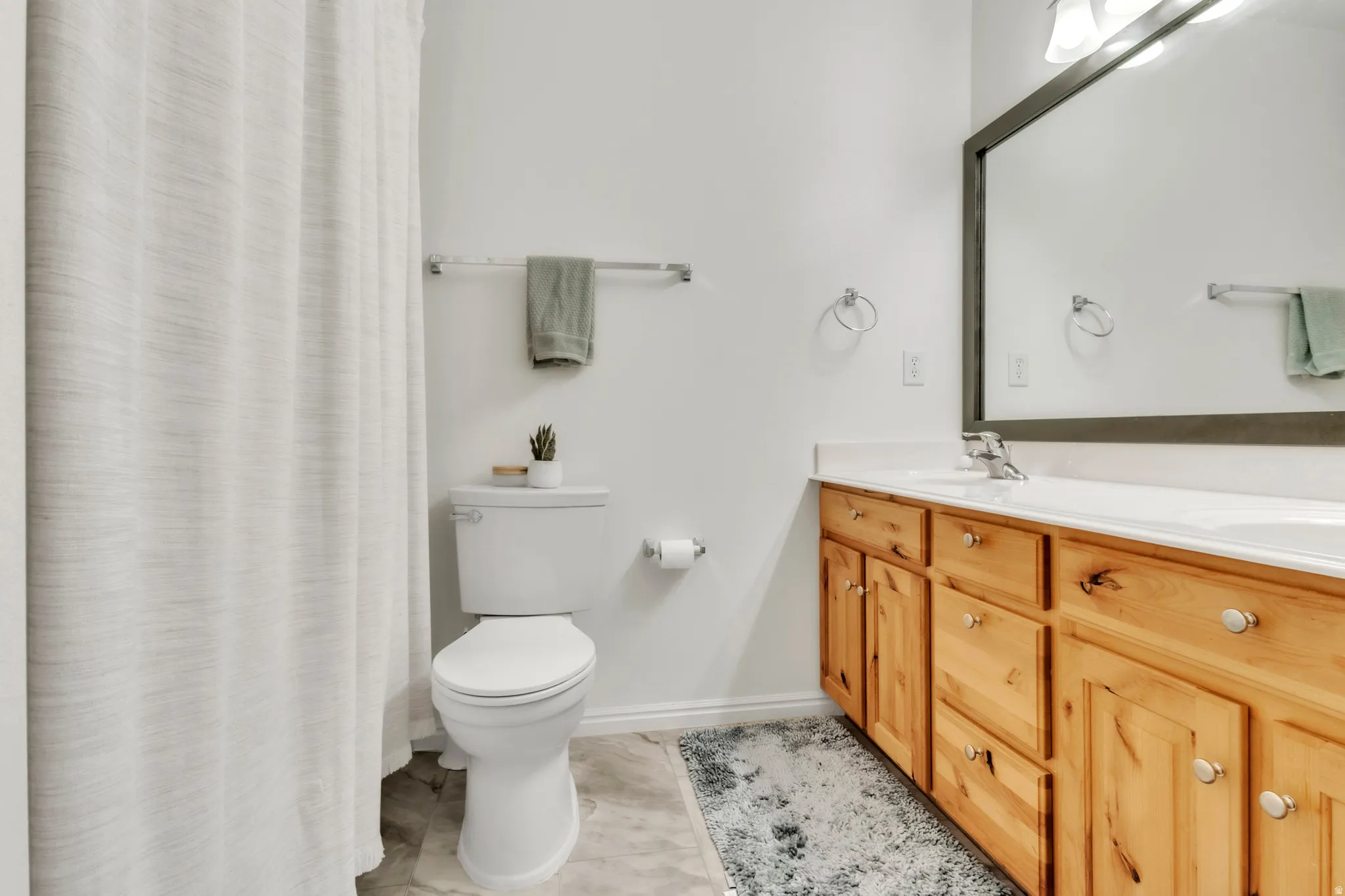 Full bath featuring double vanity and curtained shower