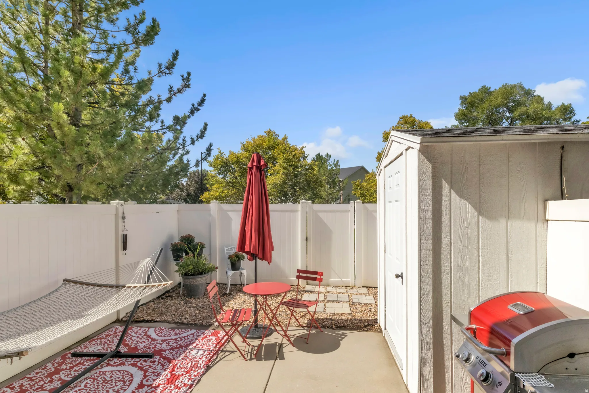 Fenced backyard with grilling area, a patio, and a storage shed