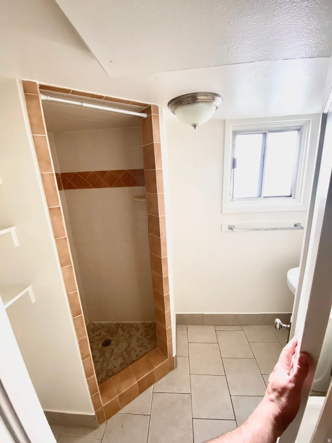 Full bath with a stall shower and light tile patterned floors