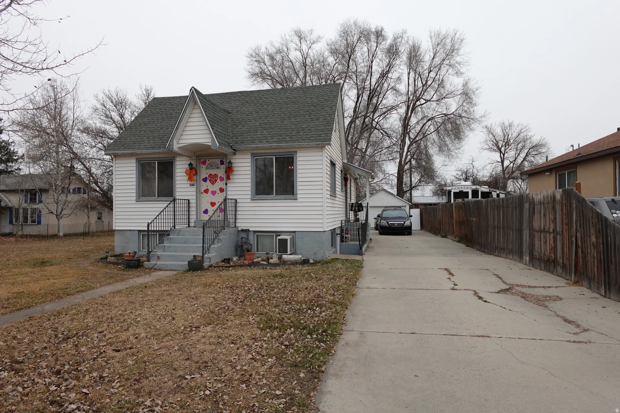 Bungalow-style home featuring a shingled roof and an outdoor structure