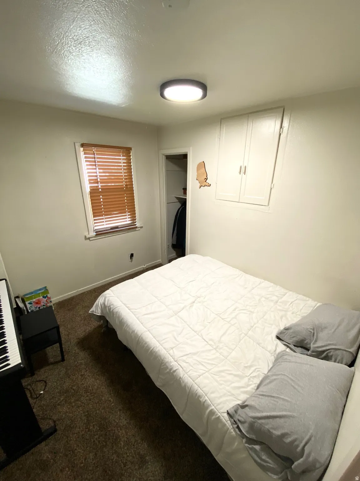 Bedroom featuring dark colored carpet and a textured ceiling