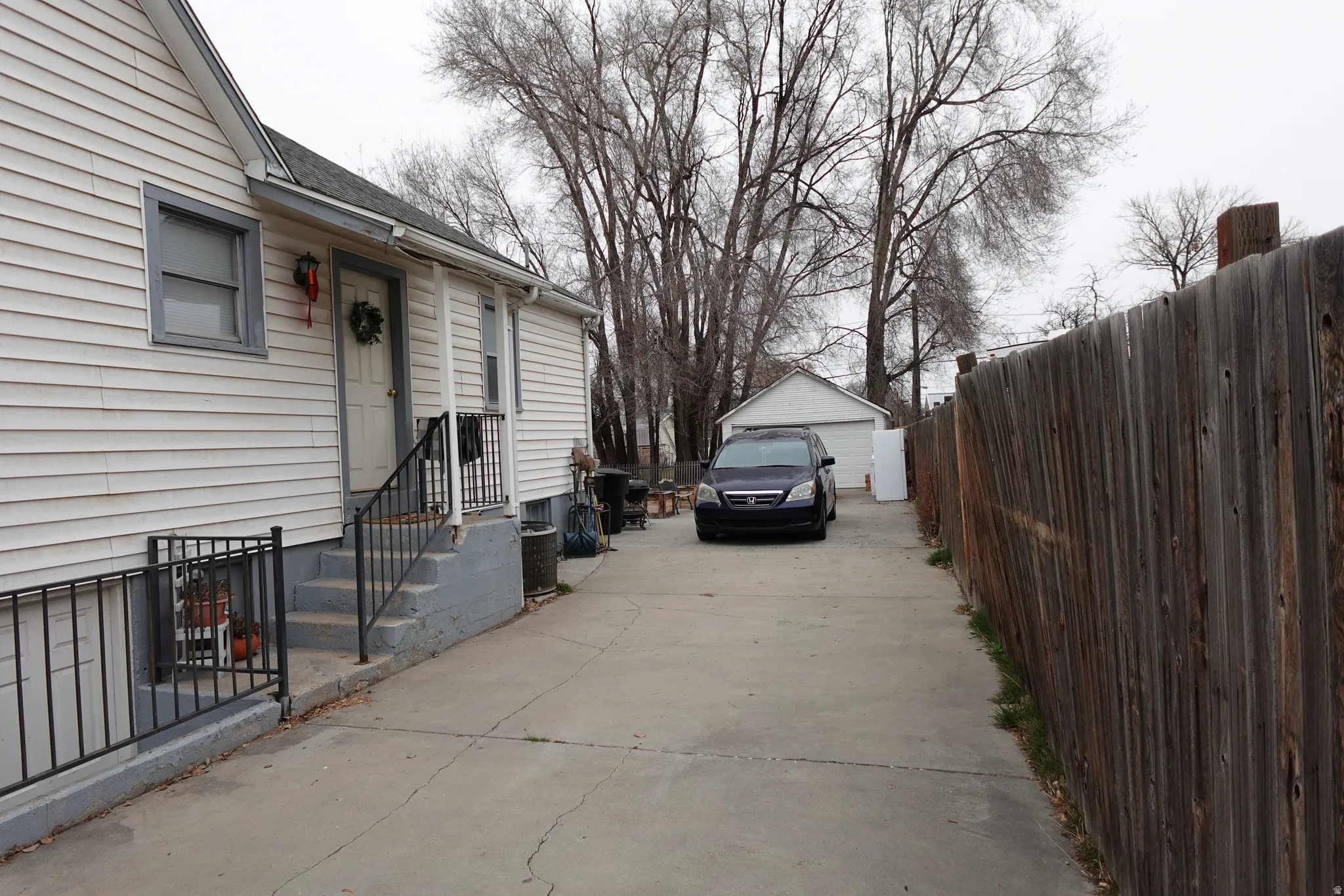 View of side of property featuring an outbuilding, a detached garage, and a shingled roof