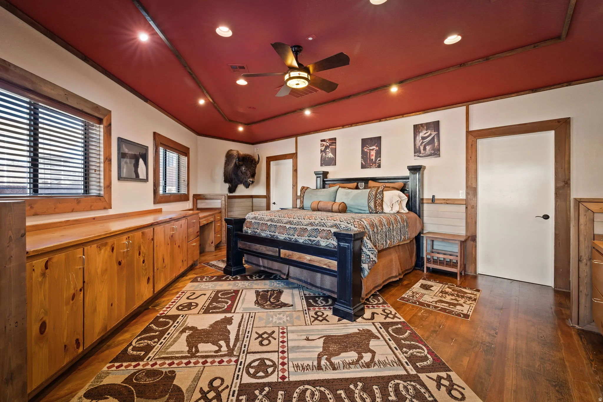 Bedroom with wainscoting, a ceiling fan, hardwood / wood-style floors, a raised ceiling, and recessed lighting