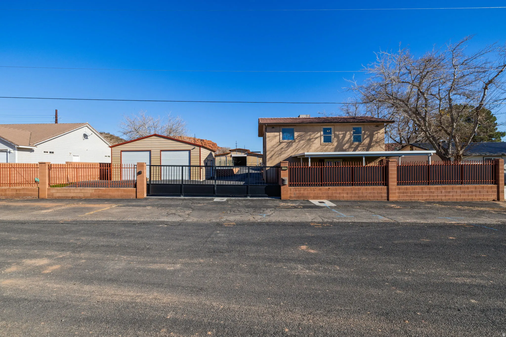 View of front of house featuring a fenced front yard, a gate, and an outbuilding