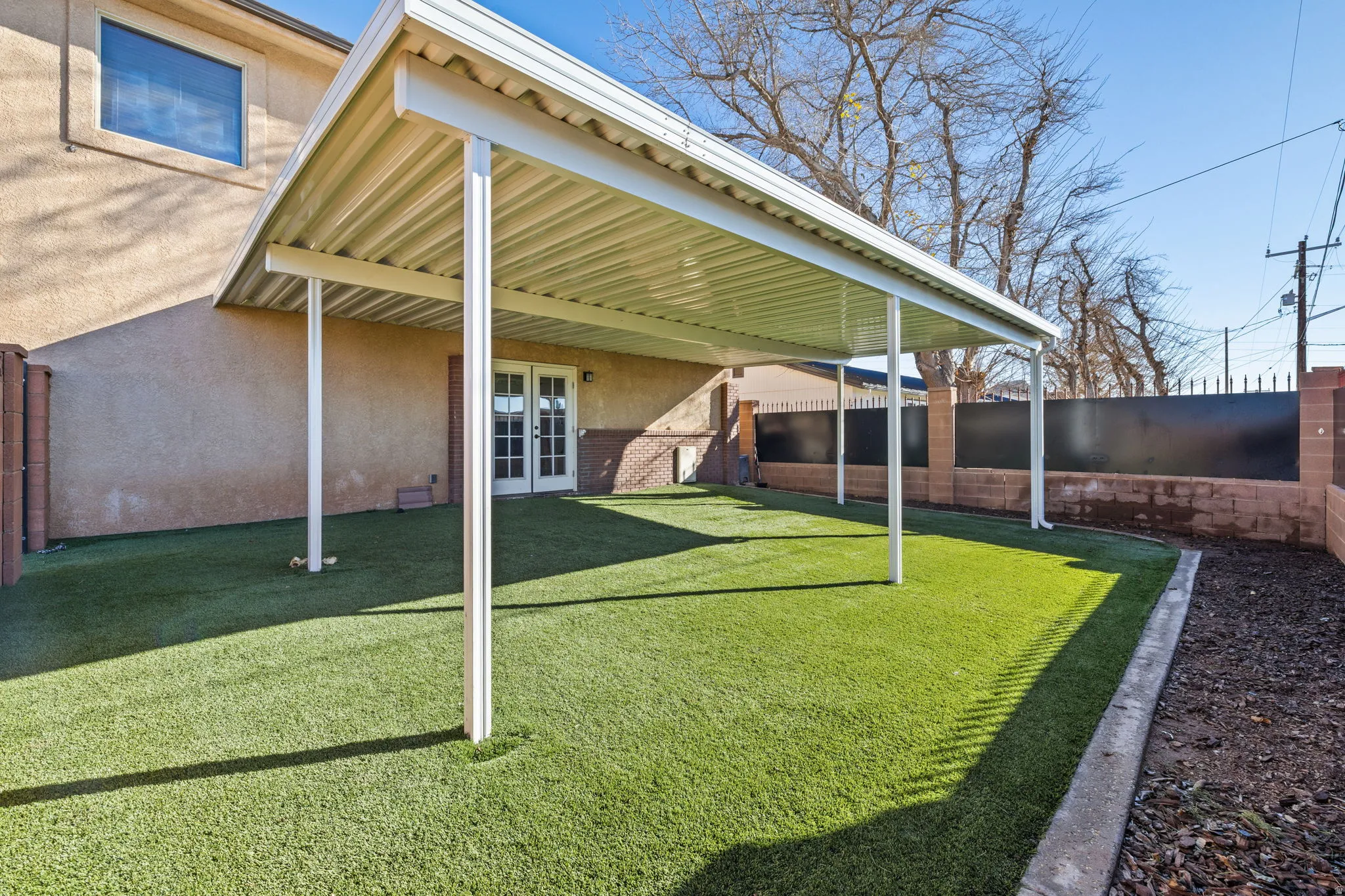 Fenced backyard featuring french doors and a patio