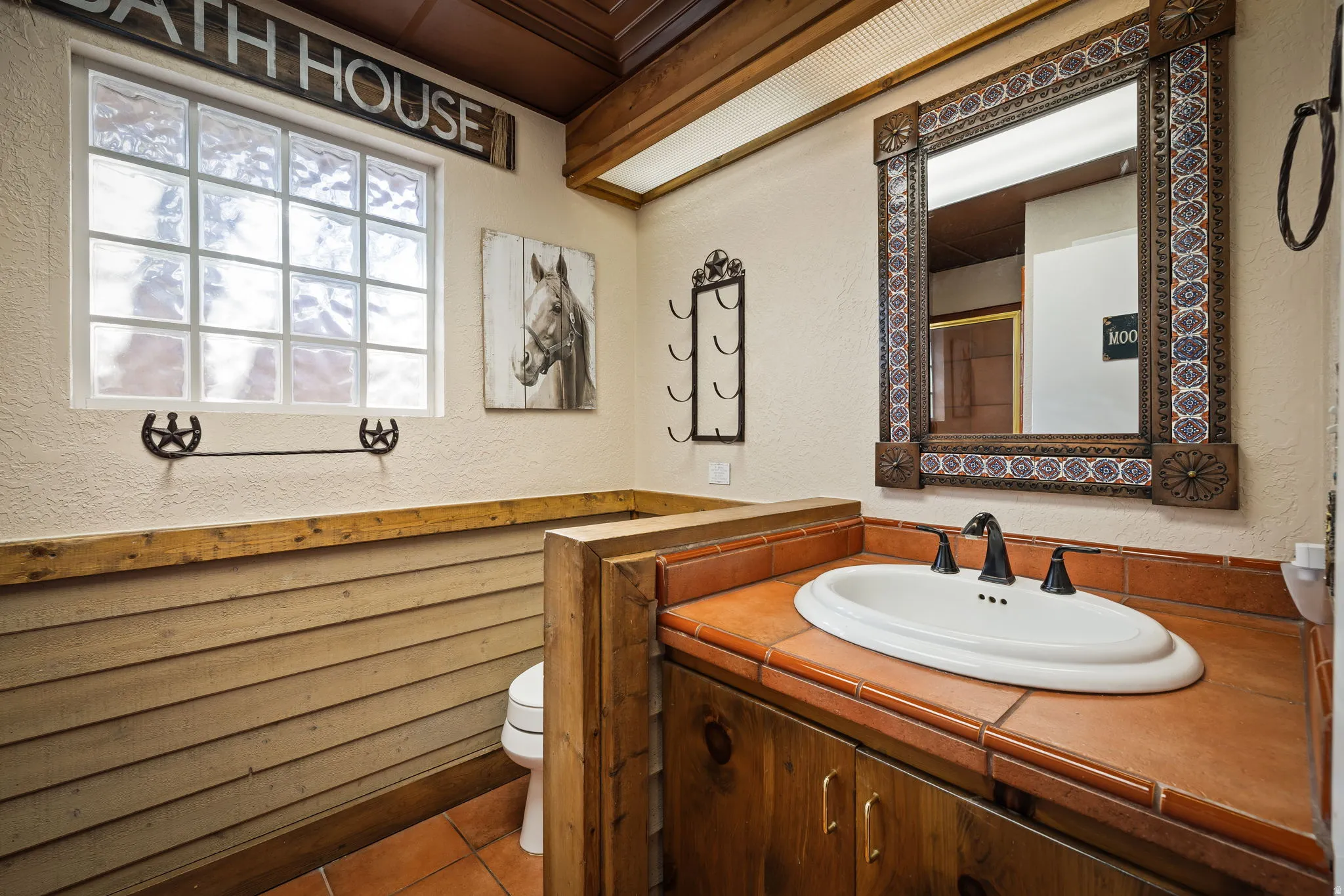 Bathroom featuring a textured wall, vanity, and tile patterned flooring