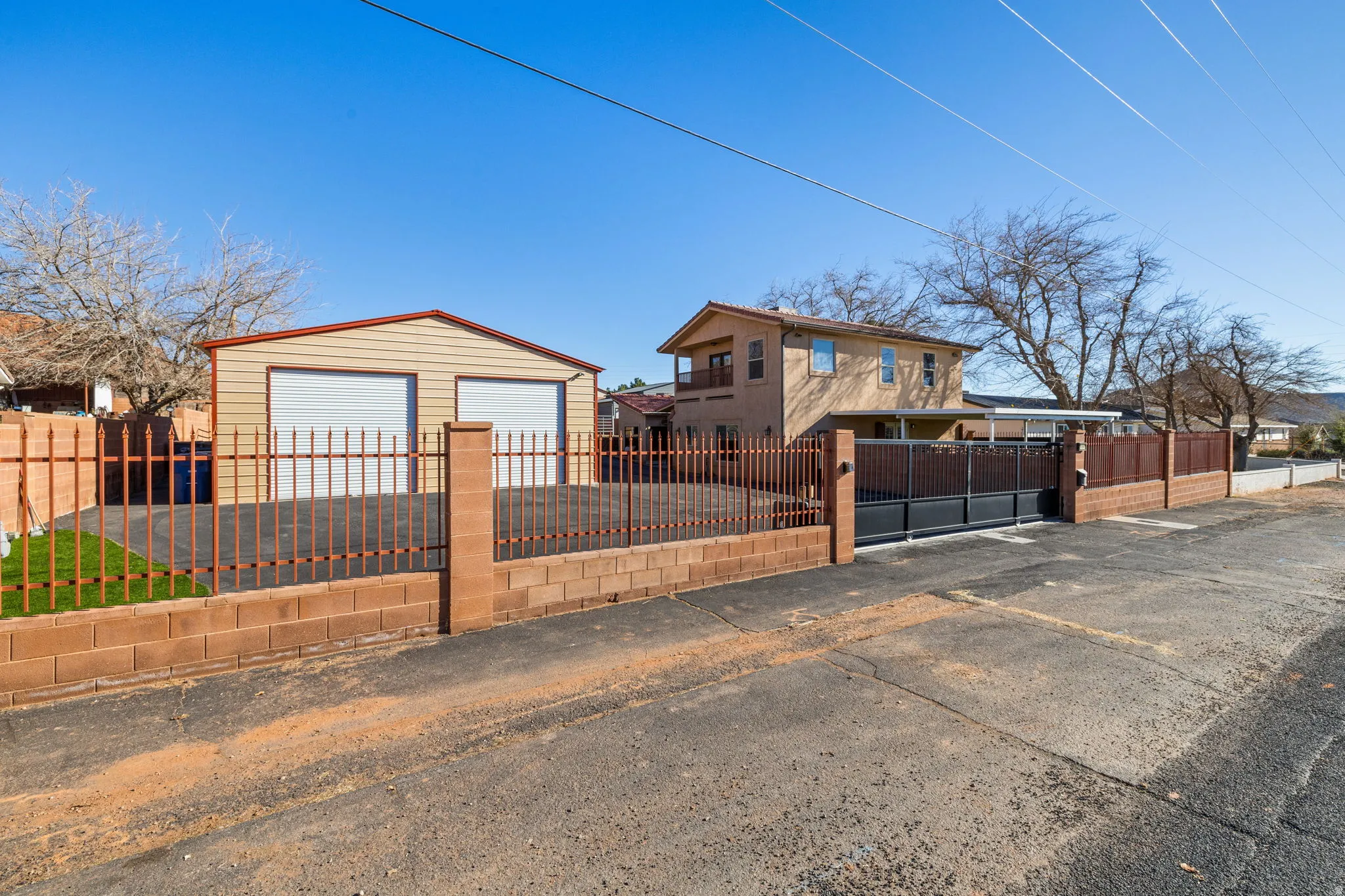 View of front of house with a fenced front yard, a garage, an outdoor structure, and a gate