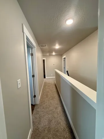 Neutral wall paint, recessed lighting, white trim, and carpeting