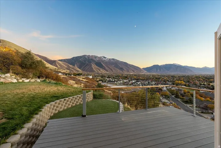 Deck at dusk with a lawn and a mountain view