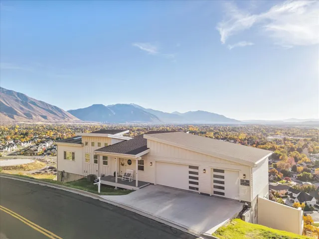 View of front of house featuring a mountain view, an attached garage, concrete driveway, and a residential view