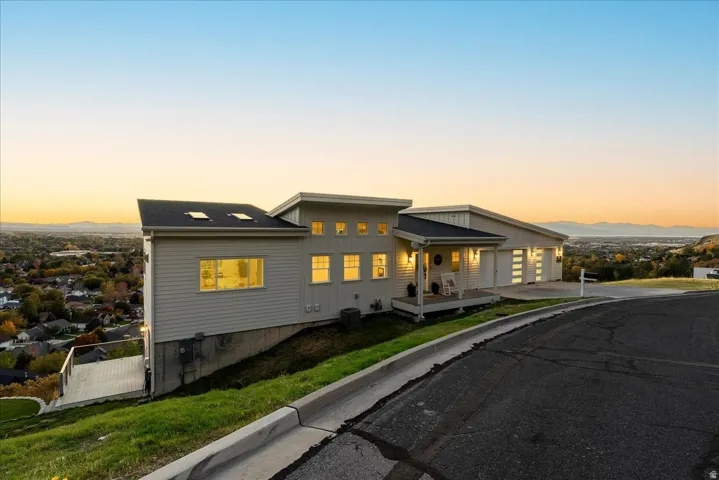 View of front of home featuring covered porch, board and batten siding, a gate, and driveway