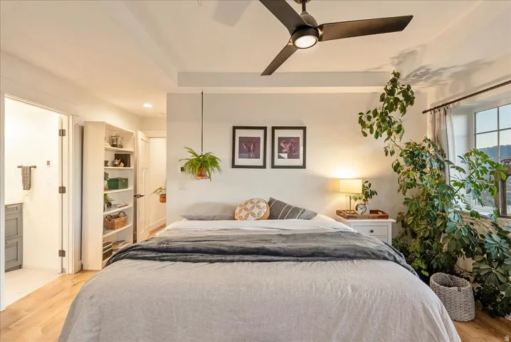 Bedroom featuring light wood-style flooring, a ceiling fan, connected bathroom, and recessed lighting