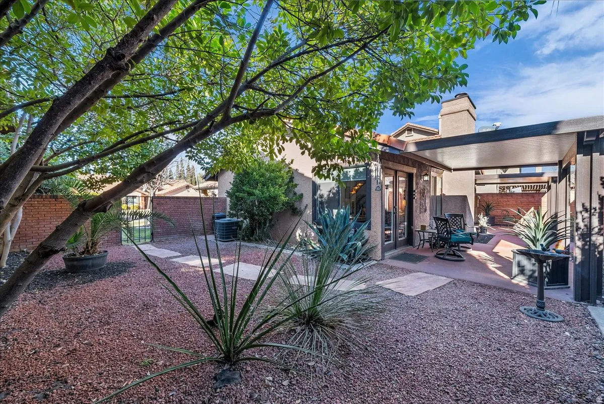 Rear view of property featuring a fenced backyard, stucco siding, a patio area, a chimney, and french doors