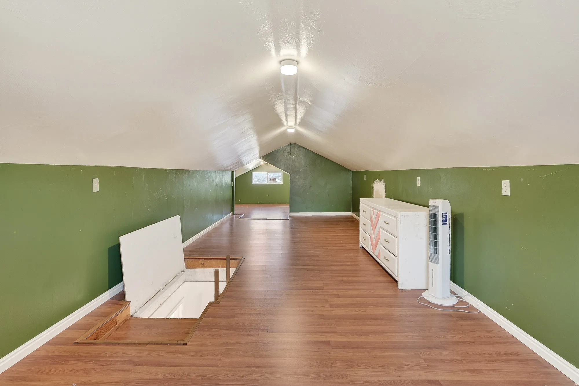 Bonus room with lofted ceiling and light wood-type flooring