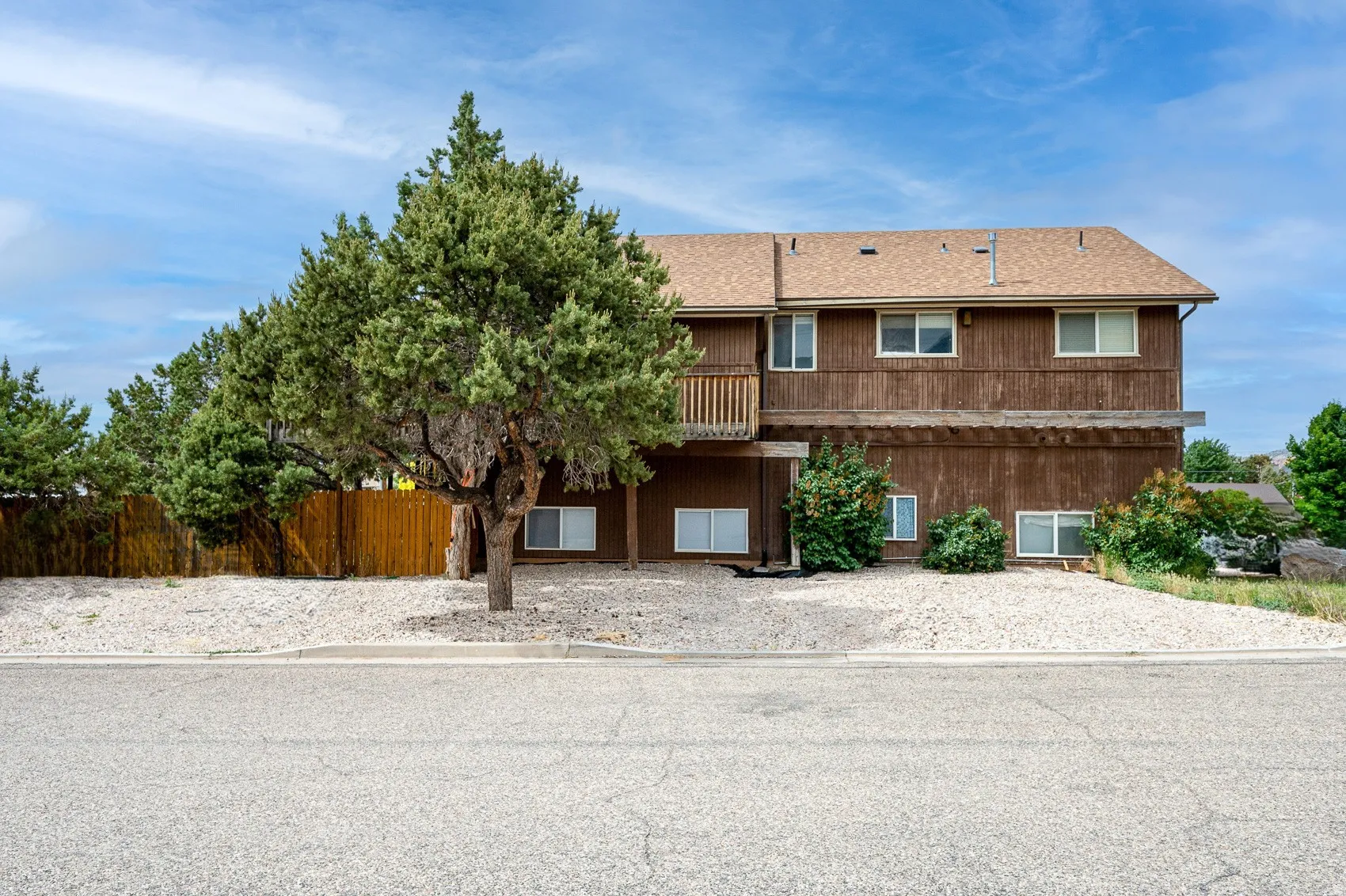 View of front of house featuring a balcony and roof with shingles