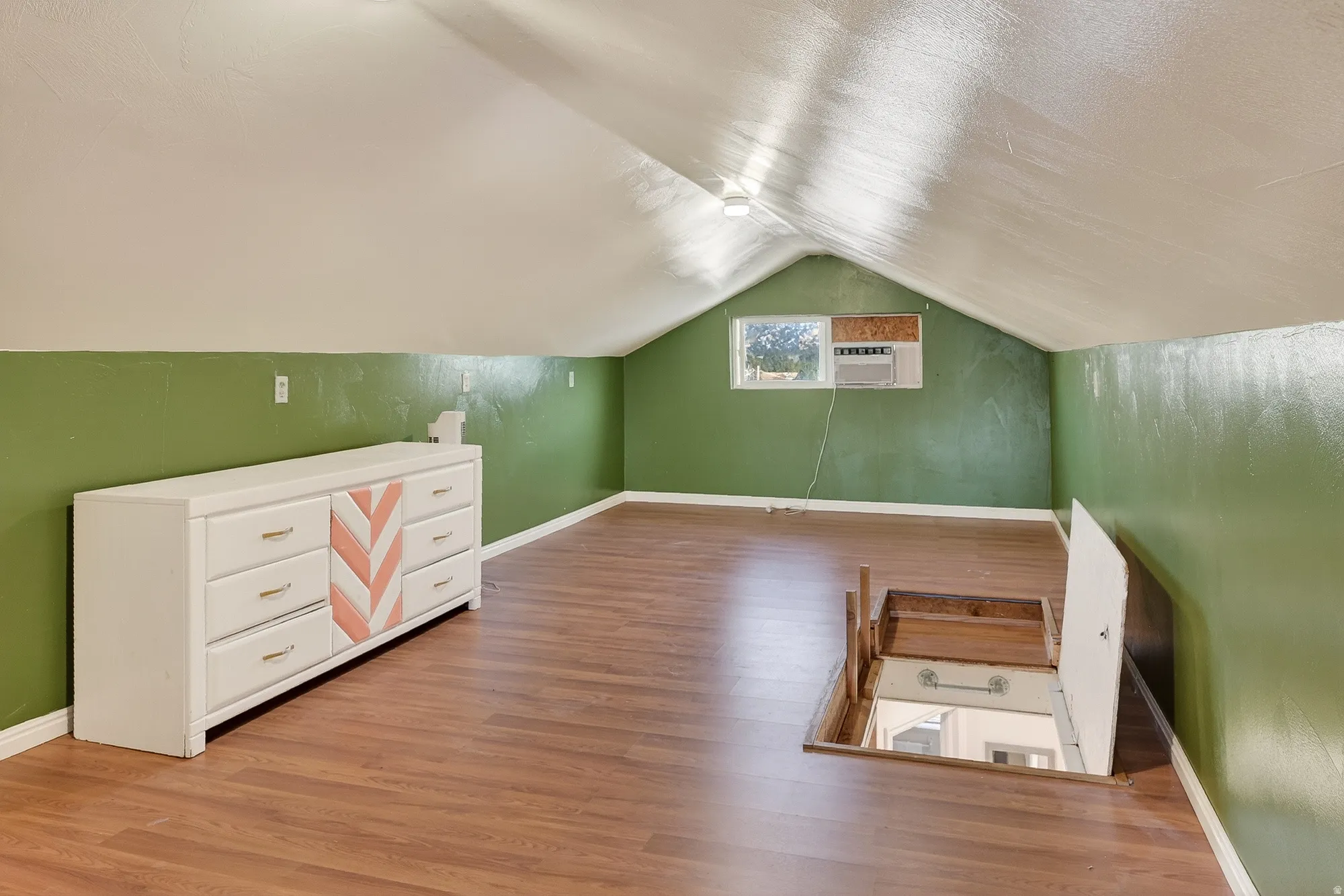Additional living space with vaulted ceiling and light wood-type flooring