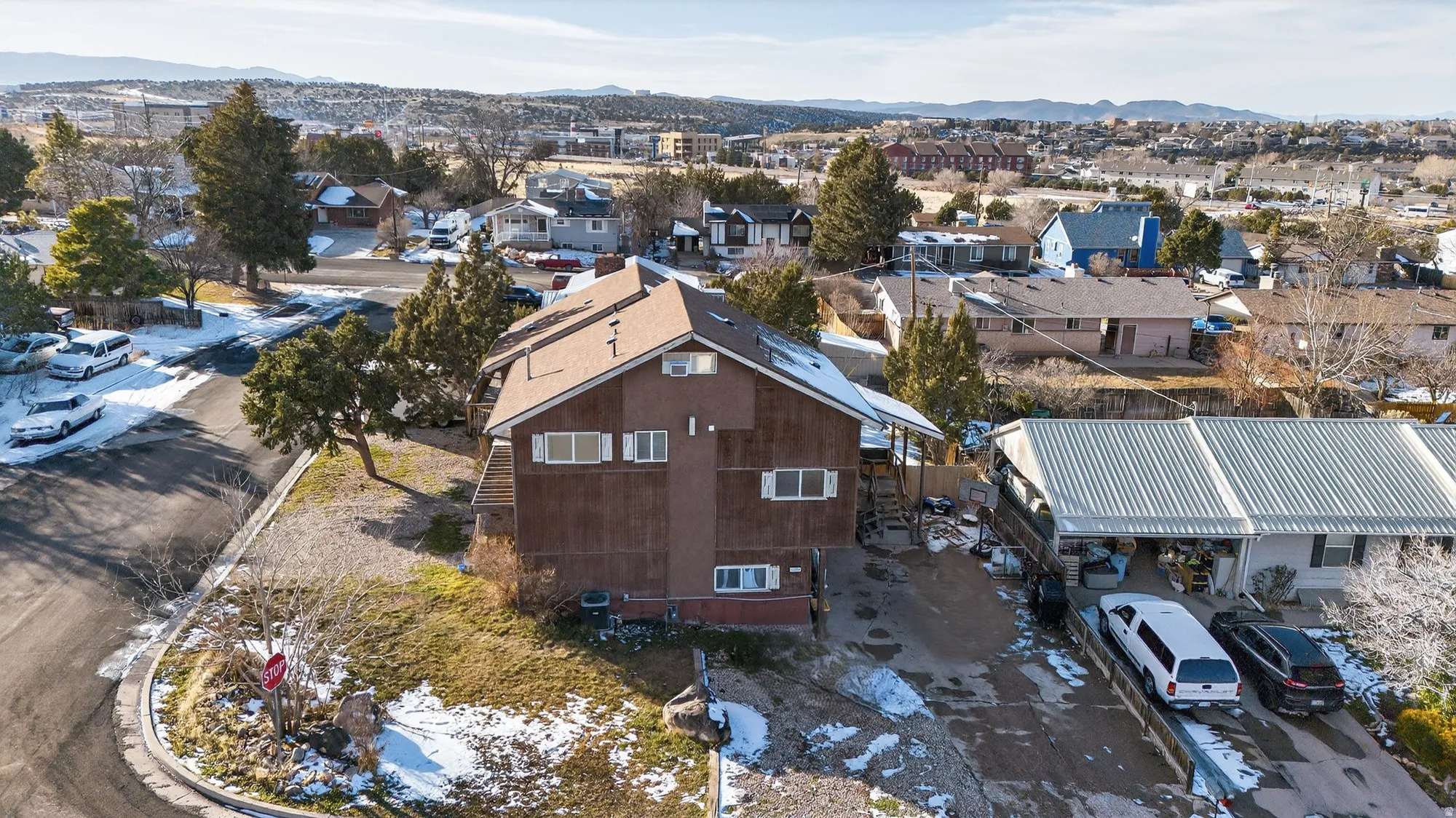 Snowy aerial view with a mountain view and a residential view