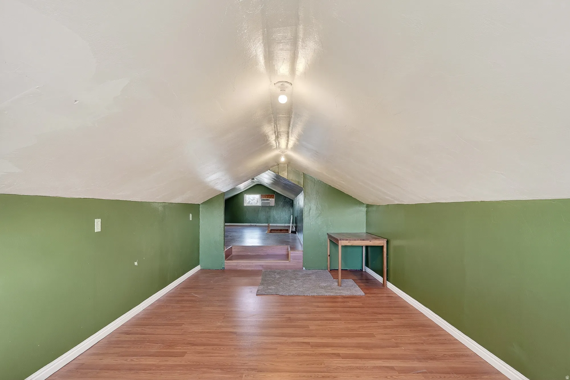 Bonus room featuring wood finished floors and lofted ceiling