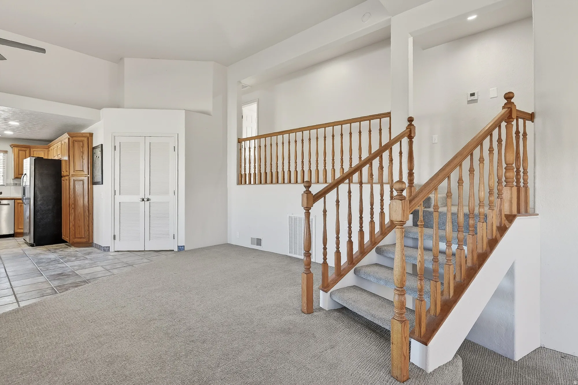 Stairway featuring carpet floors, a high ceiling, and recessed lighting