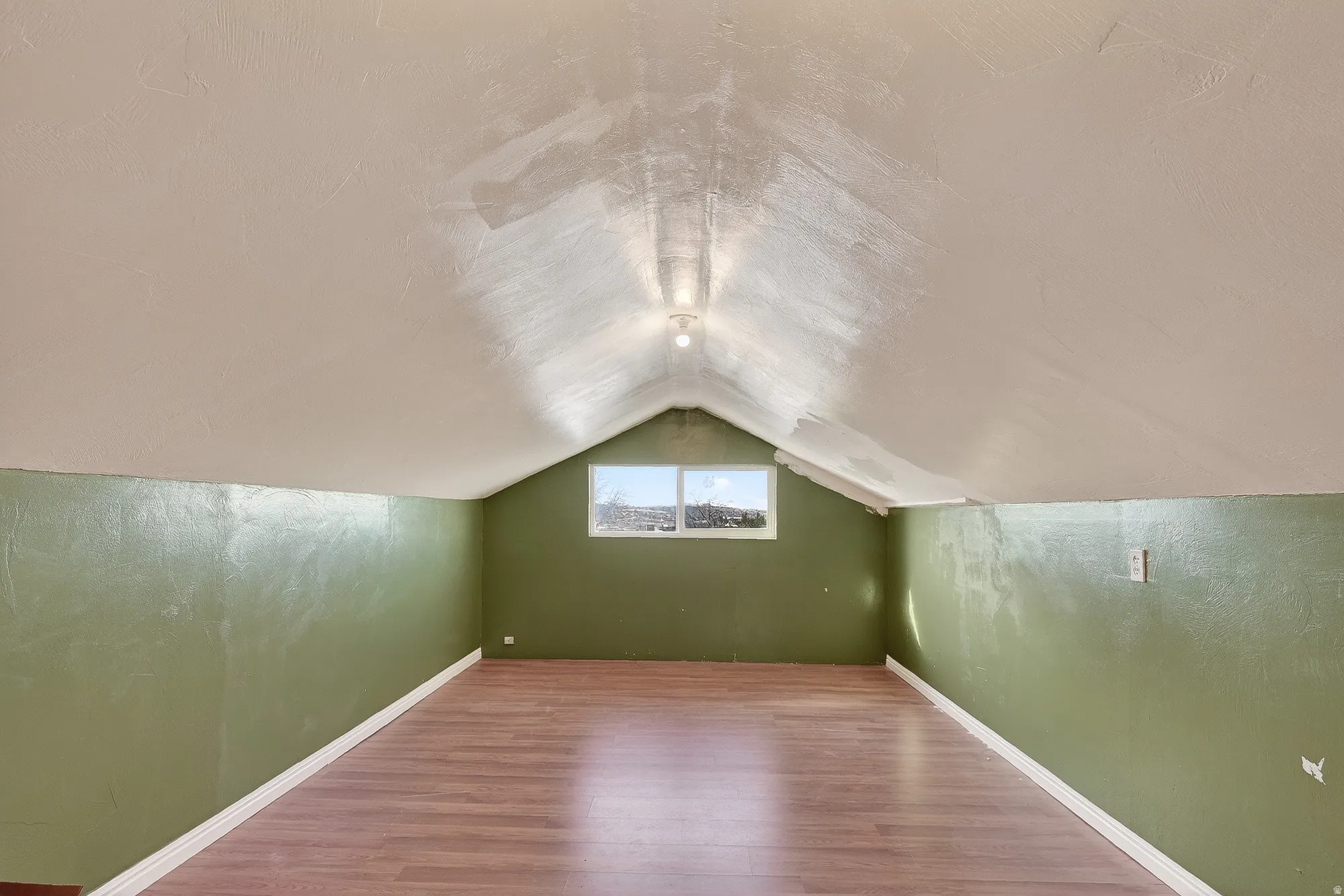 Additional living space featuring vaulted ceiling and wood finished floors