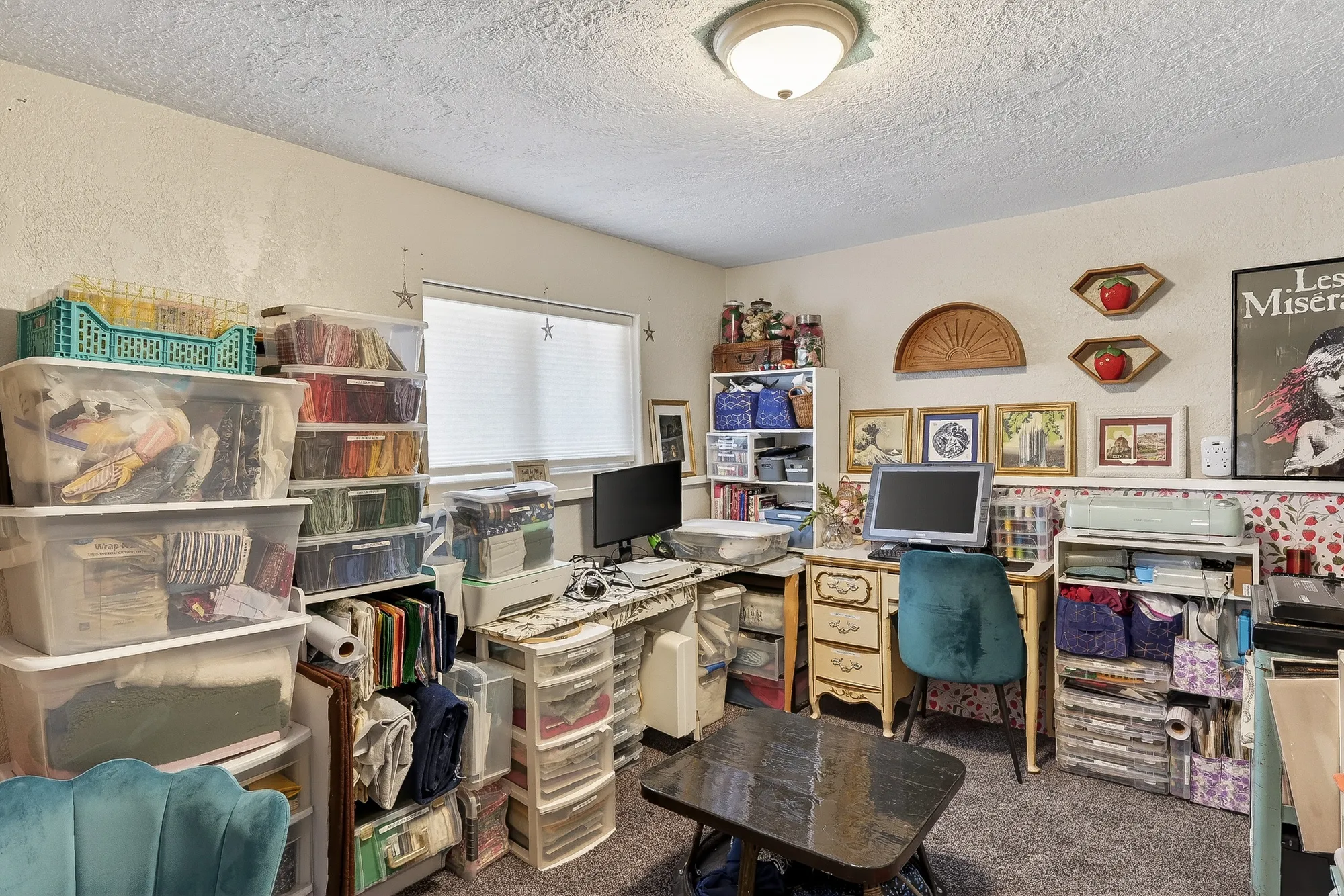 Office area featuring carpet flooring, a textured ceiling, and a textured wall