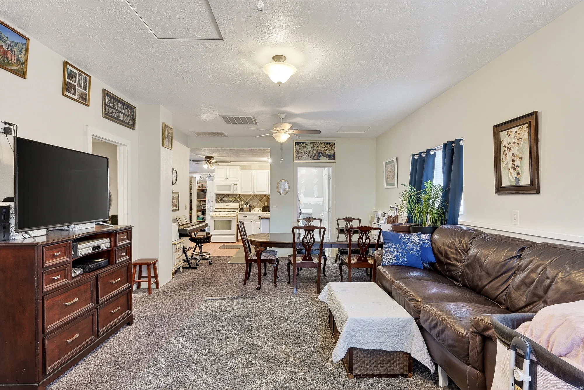 Living room with a textured ceiling and dark carpet