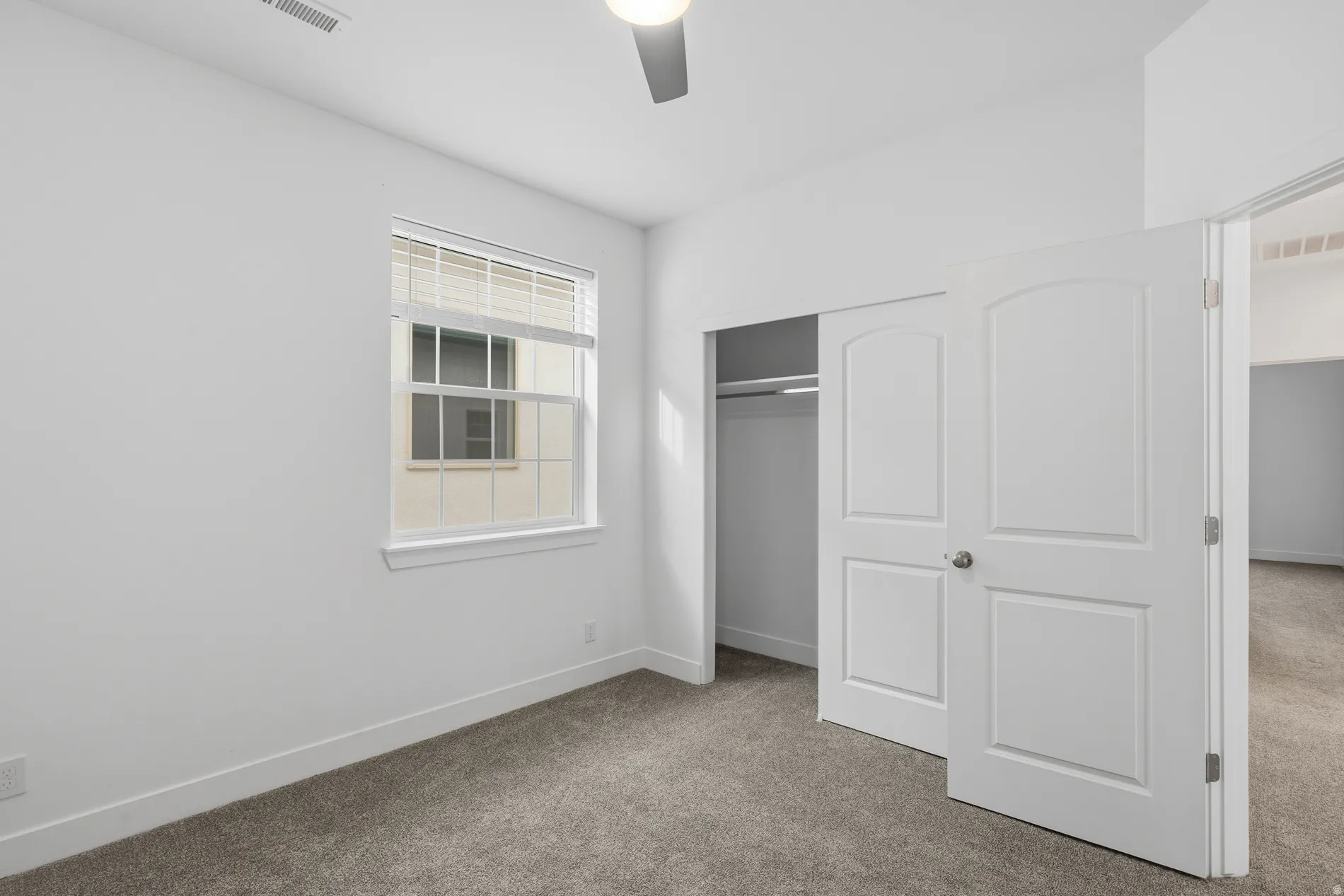 Unfurnished bedroom with carpet floors, a closet, and a ceiling fan