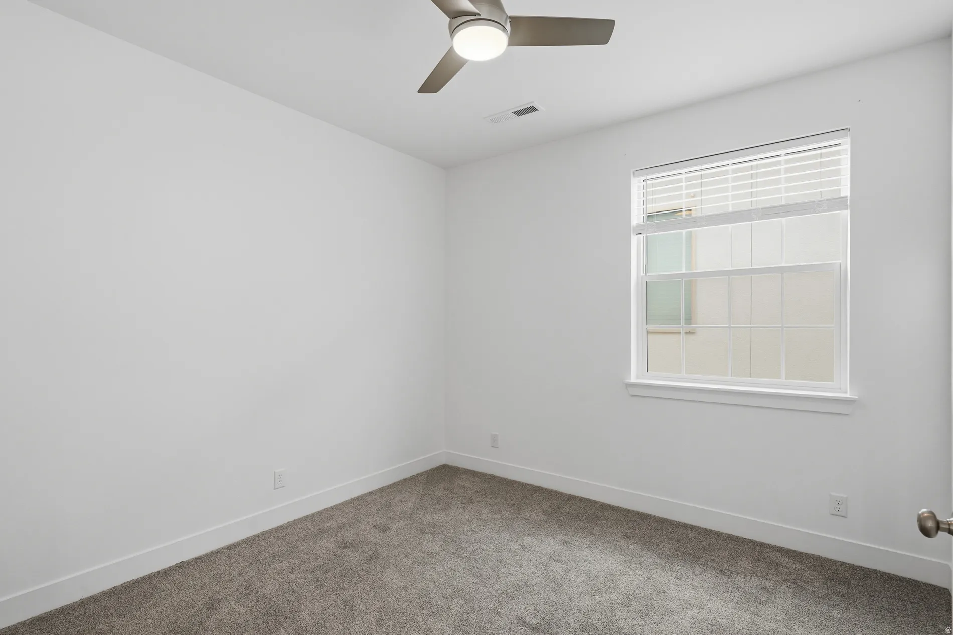 Carpeted empty room with baseboards and ceiling fan