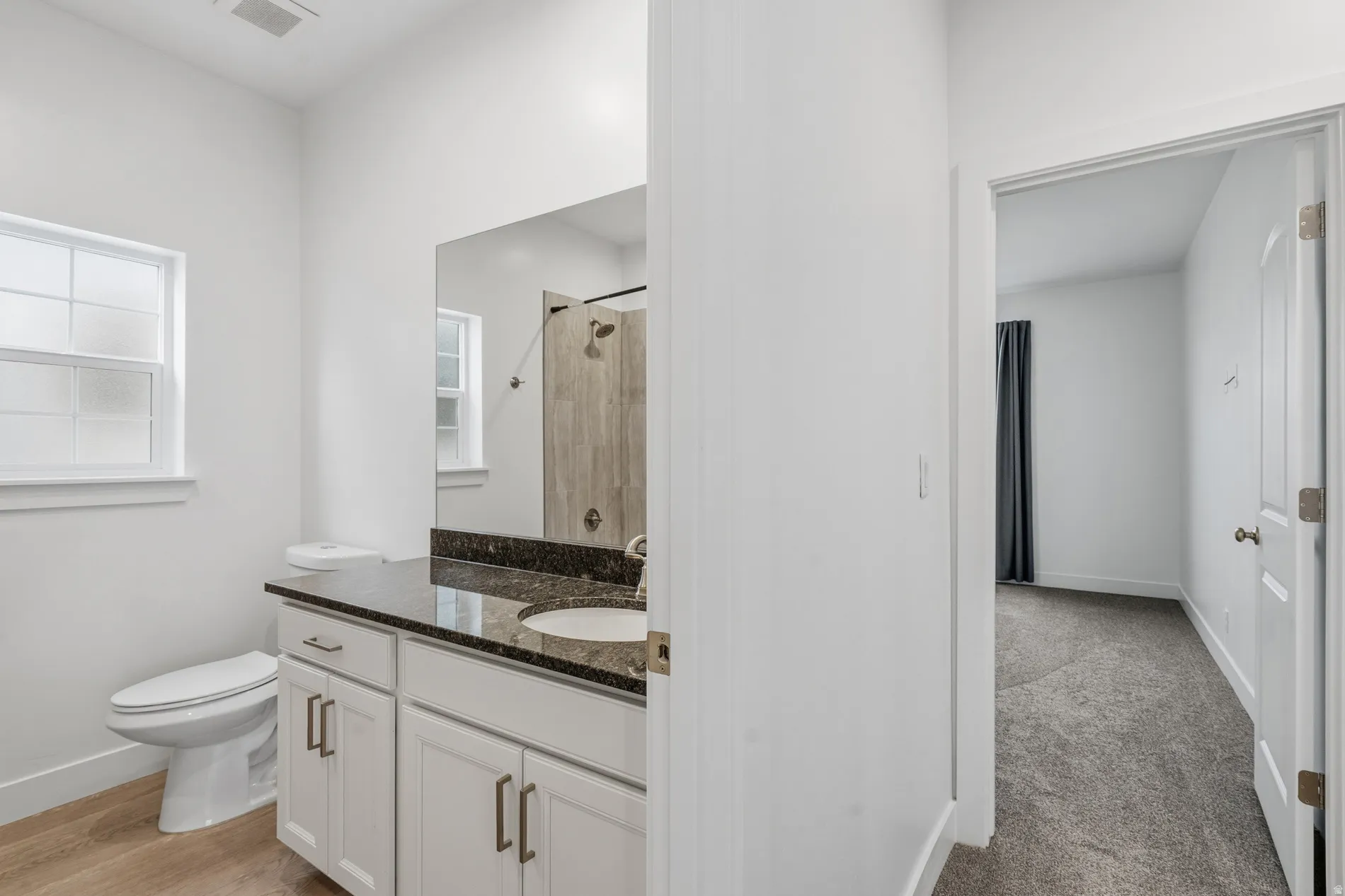 Bathroom featuring a tile shower and vanity