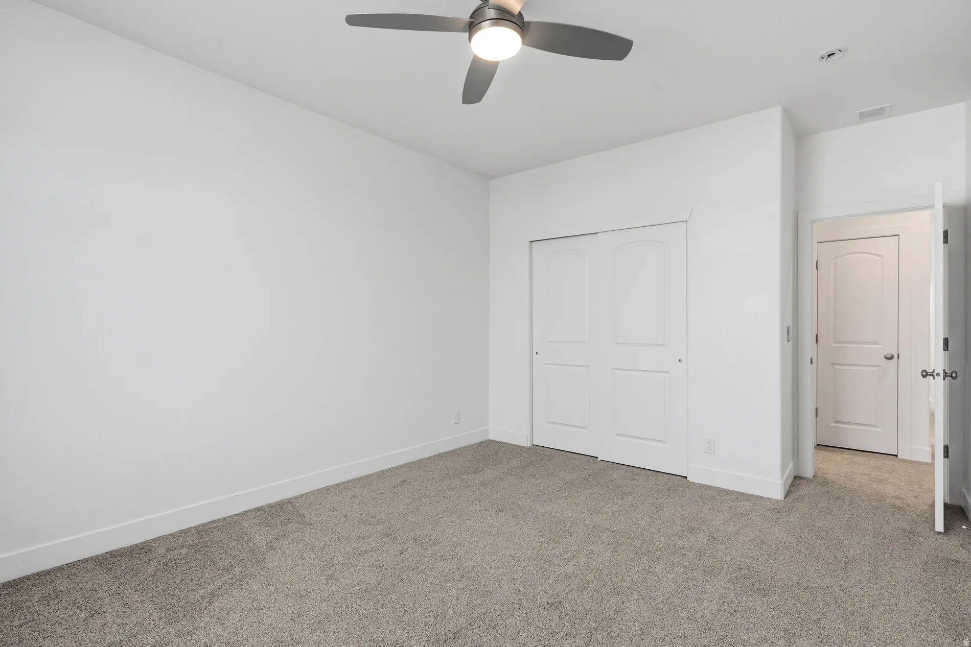 Unfurnished bedroom with carpet flooring, a closet, and a ceiling fan