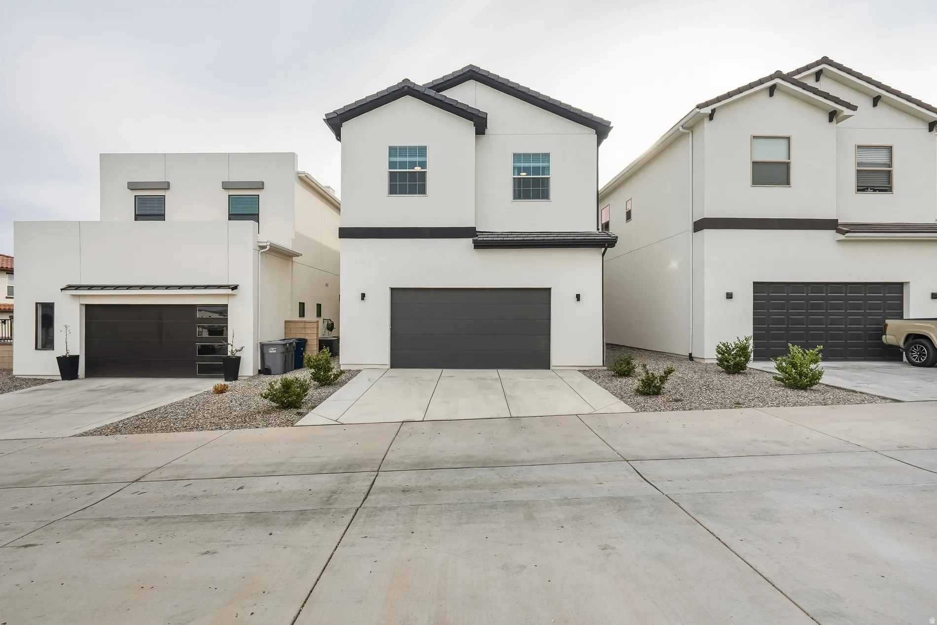 View of front of property featuring stucco siding, concrete driveway, and a garage