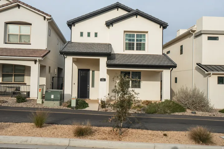 View of front of home featuring covered porch, stucco siding, and a tile roof