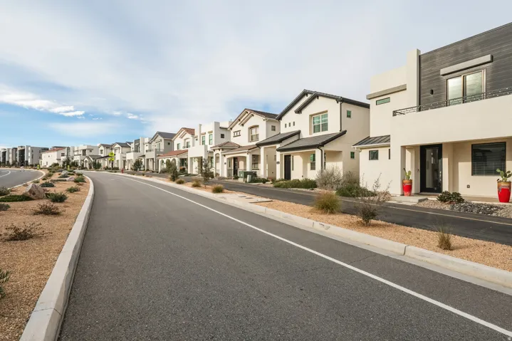 View of asphalt road featuring a residential view and curbs