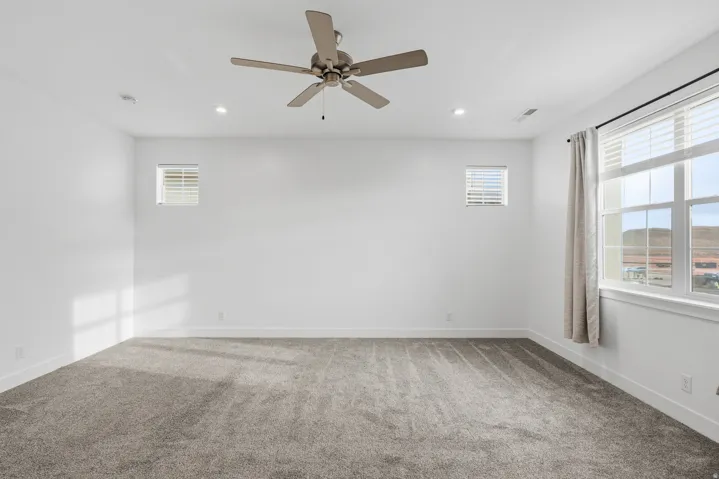 Empty room featuring carpet flooring, a ceiling fan, and recessed lighting