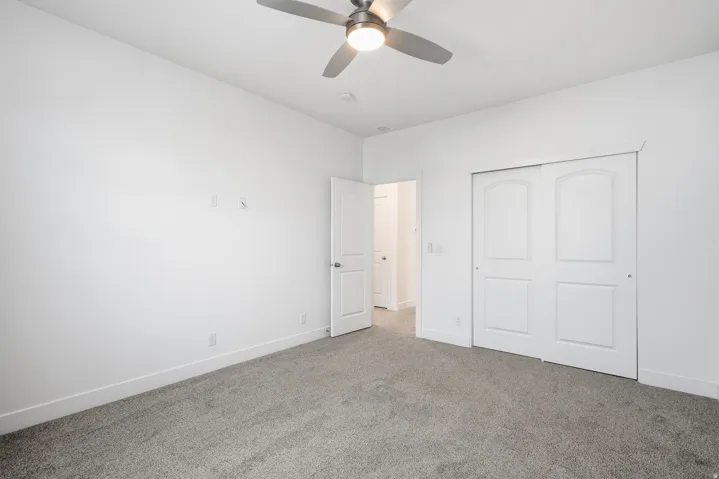 Unfurnished bedroom with carpet, a closet, and ceiling fan