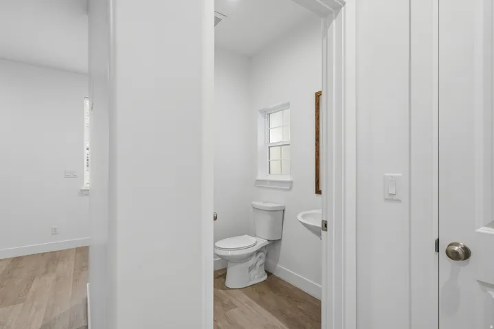 Half bath featuring light wood-type flooring and toilet