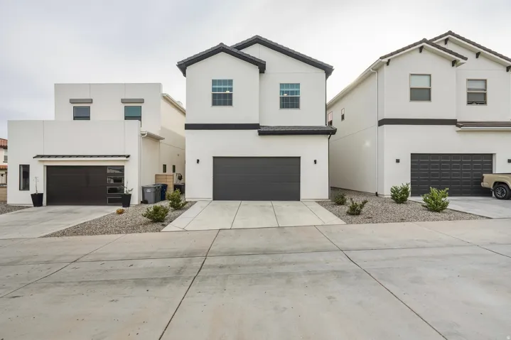 View of front of property featuring stucco siding, concrete driveway, and a garage