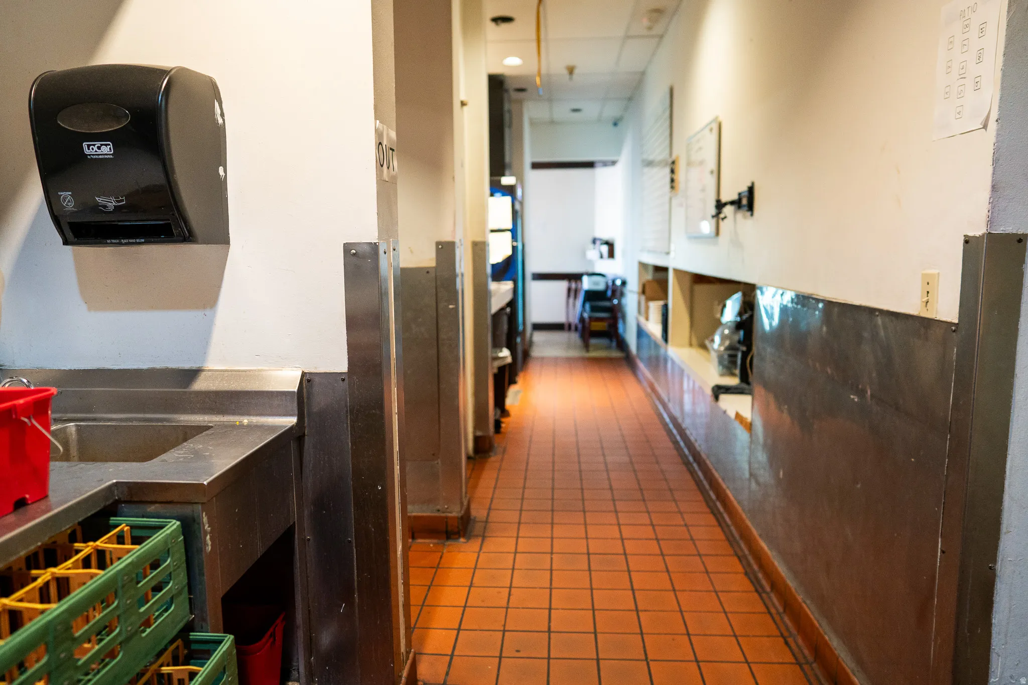 Corridor featuring dark tile patterned floors and a drop ceiling