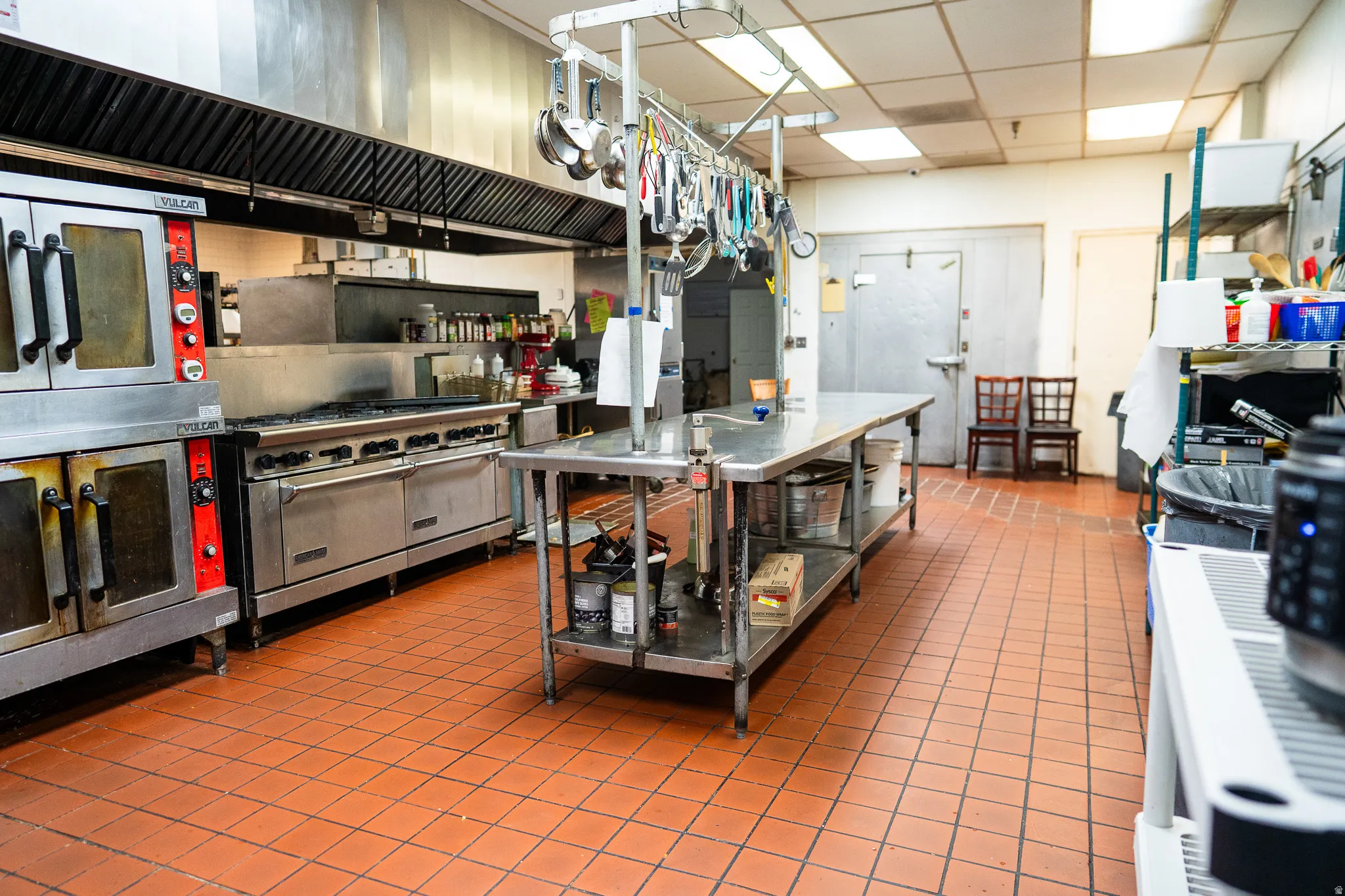 Kitchen with stainless steel counters, a paneled ceiling, and double oven range