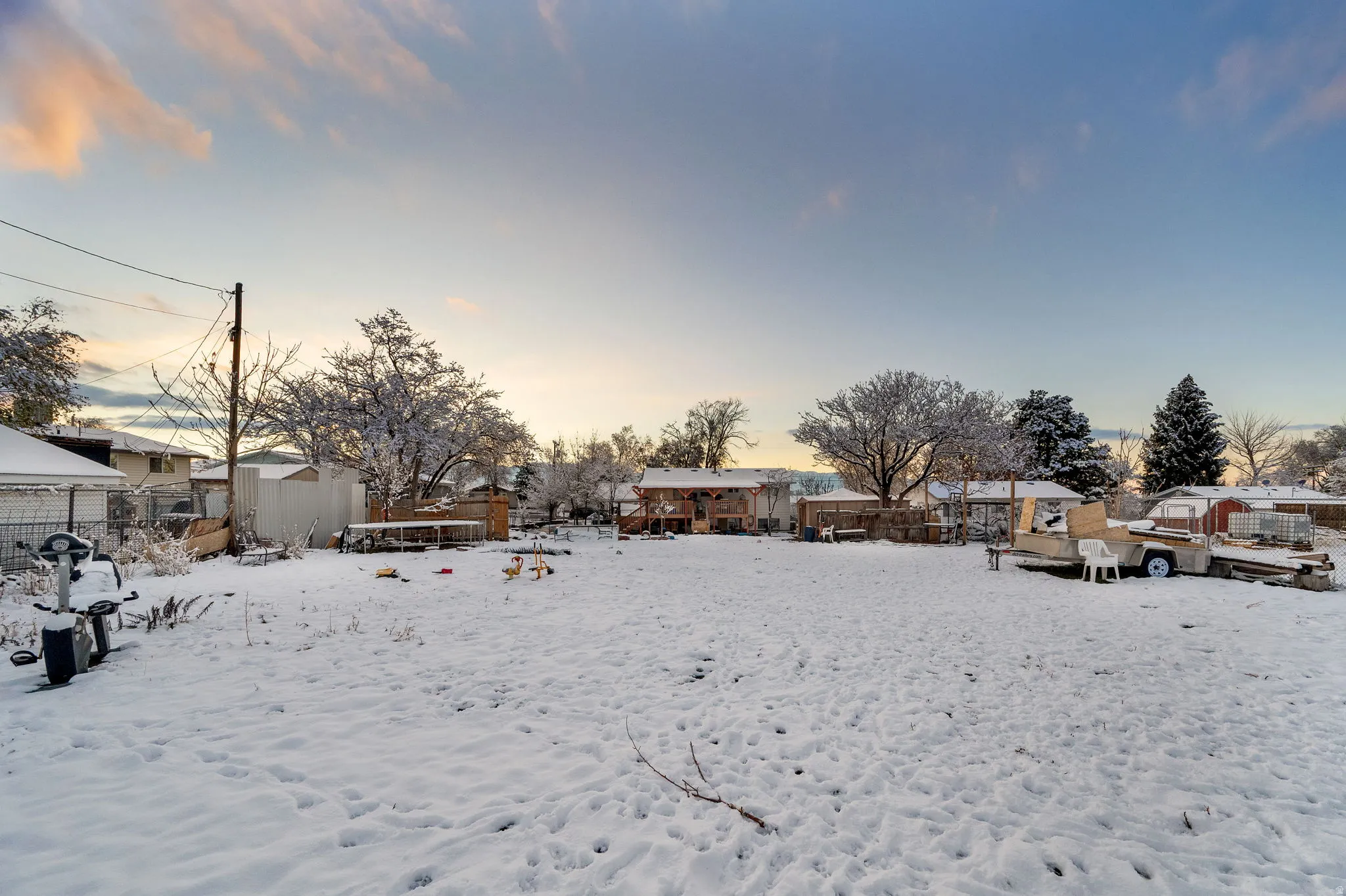 Yard covered in snow featuring a residential view and a storage unit