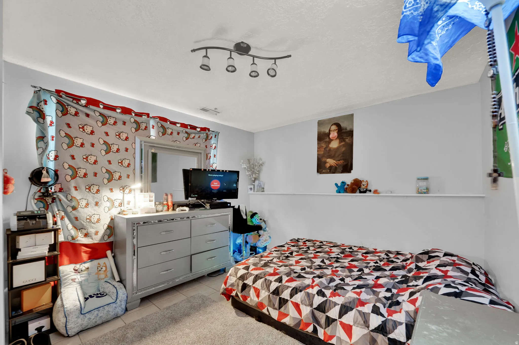 Bedroom with light tile patterned floors and a textured ceiling