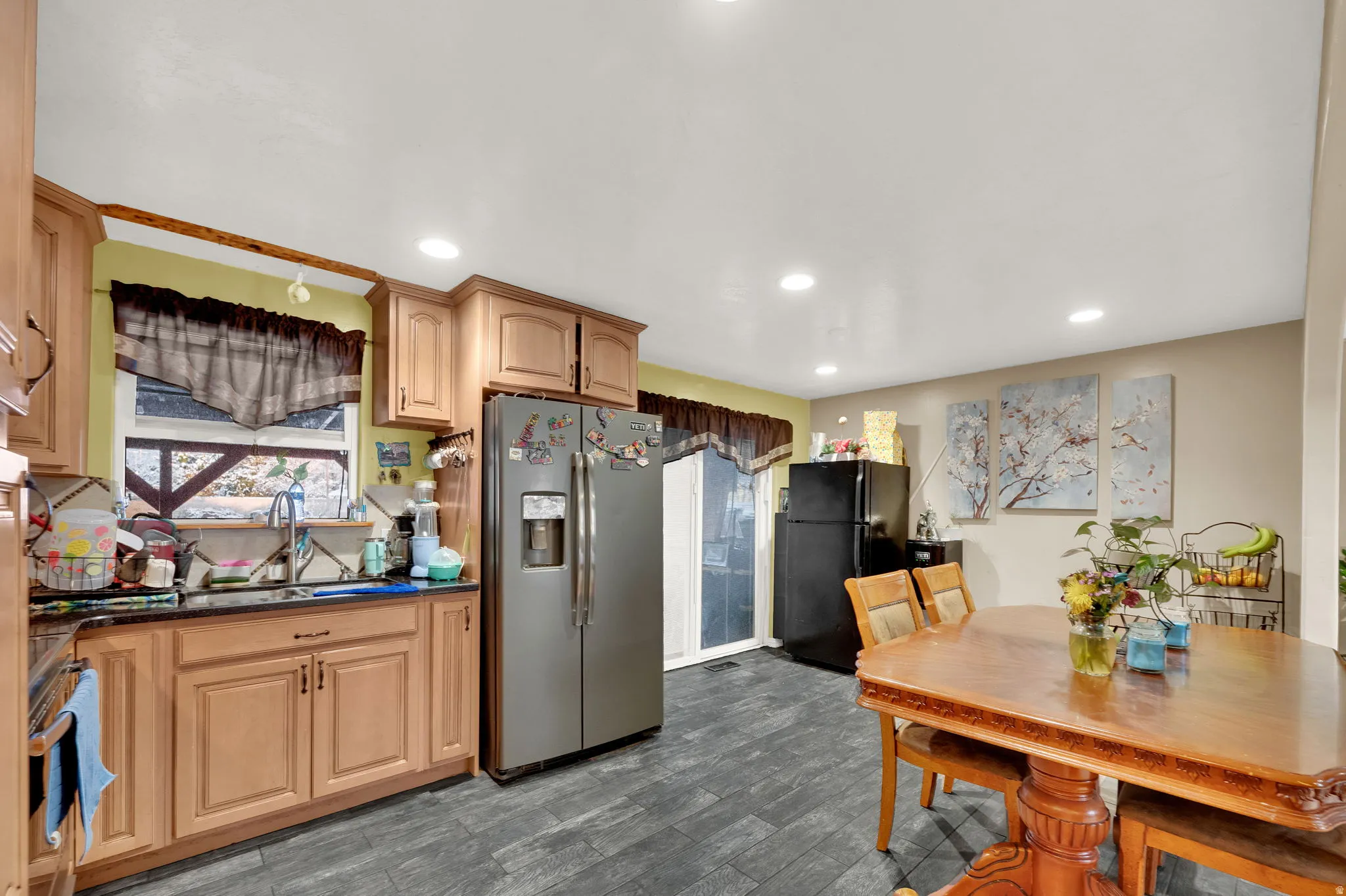 Kitchen featuring stainless steel appliances, dark wood finished floors, dark stone counters, and recessed lighting