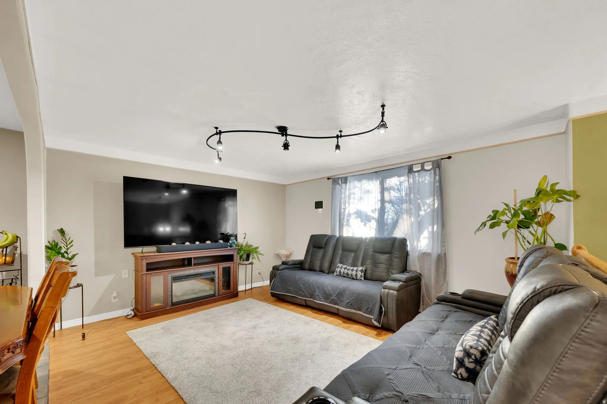 Living room with light wood-style floors and track lighting