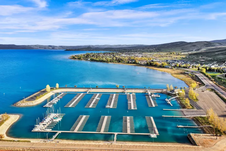 Aerial perspective showcasing a marina with numerous boat slips, set against a expansive body of water
